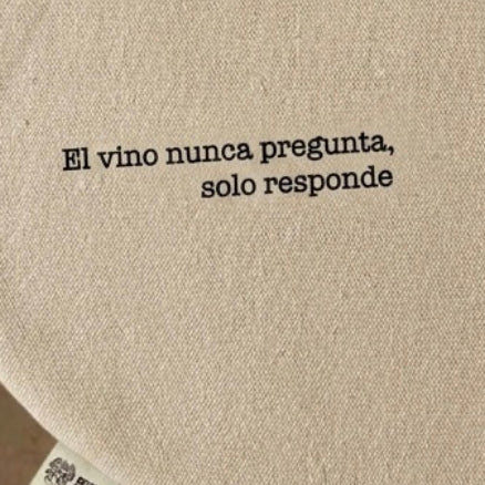 Mantel individual beige con frase “El vino nunca pregunta, solo responde”