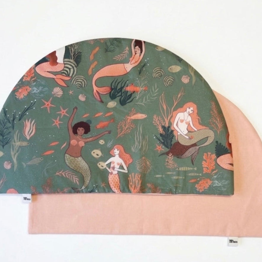 Protege tu mesa con estilo con este mantel individual de sirenas reversible y personalizable en color melocotón. Su original diseño en media luna se adapta perfectamente a cualquier espacio. Fabricado en algodón  de calidad, es el complemento ideal para una mesa infantil bonita y limpia.