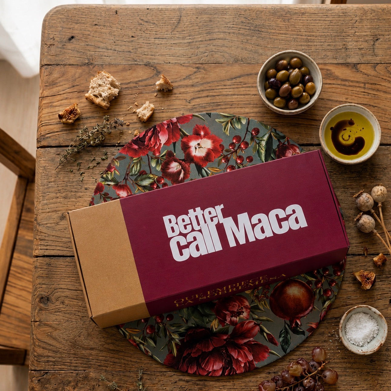 caja packaging manteles de algodon reversible con estampado de granadas y flores. sobre una mesa de estilo rústico mediterráneo 