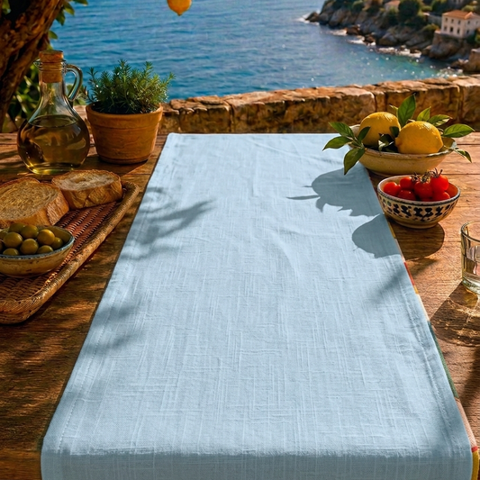 camino de mesa estampado y reversible con fondo beige y dibujos de latas y reves azul claro en fondo mediterráneo