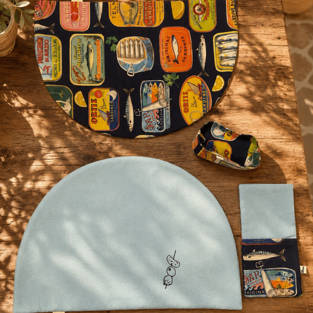 combinación manteles media luna con servilleta y panera en tejidos de algodon con estampado de latas y fondo azul marino