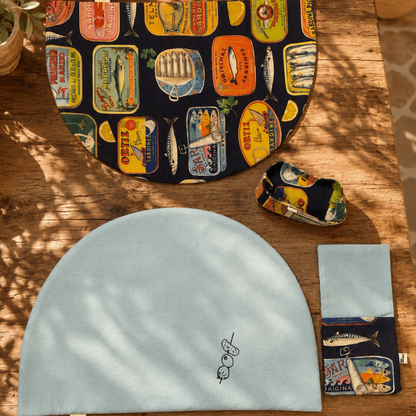 combinación manteles media luna con servilleta y panera en tejidos de algodon con estampado de latas y fondo azul marino