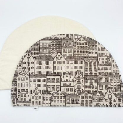 mantel individual reversible de algodón con forma de media luna relleno, estampados de casitas en tonos neutros y revés beige
personalizable con frases
