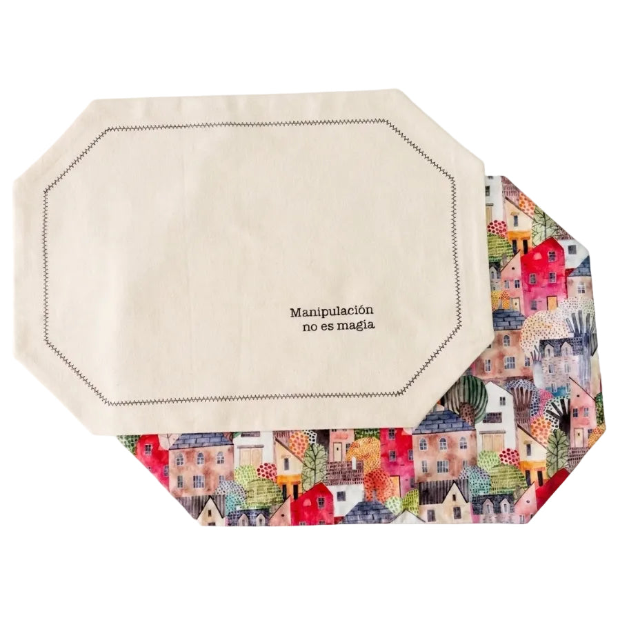 Pack de 4 manteles reversibles con estampado de casitas de colores y lino beige. Frase incluida, diseño único y listos para una sobremesa con carácter.