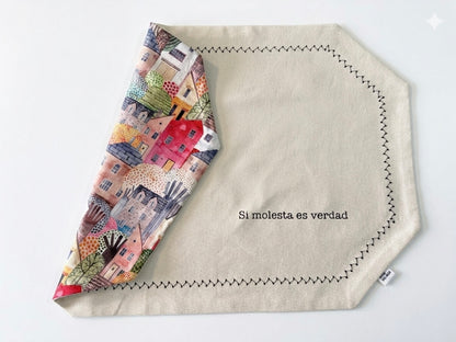 mantel individual reversible rectangular con frase con estampado de casitas de colores y reves beige con frase serigrafiada