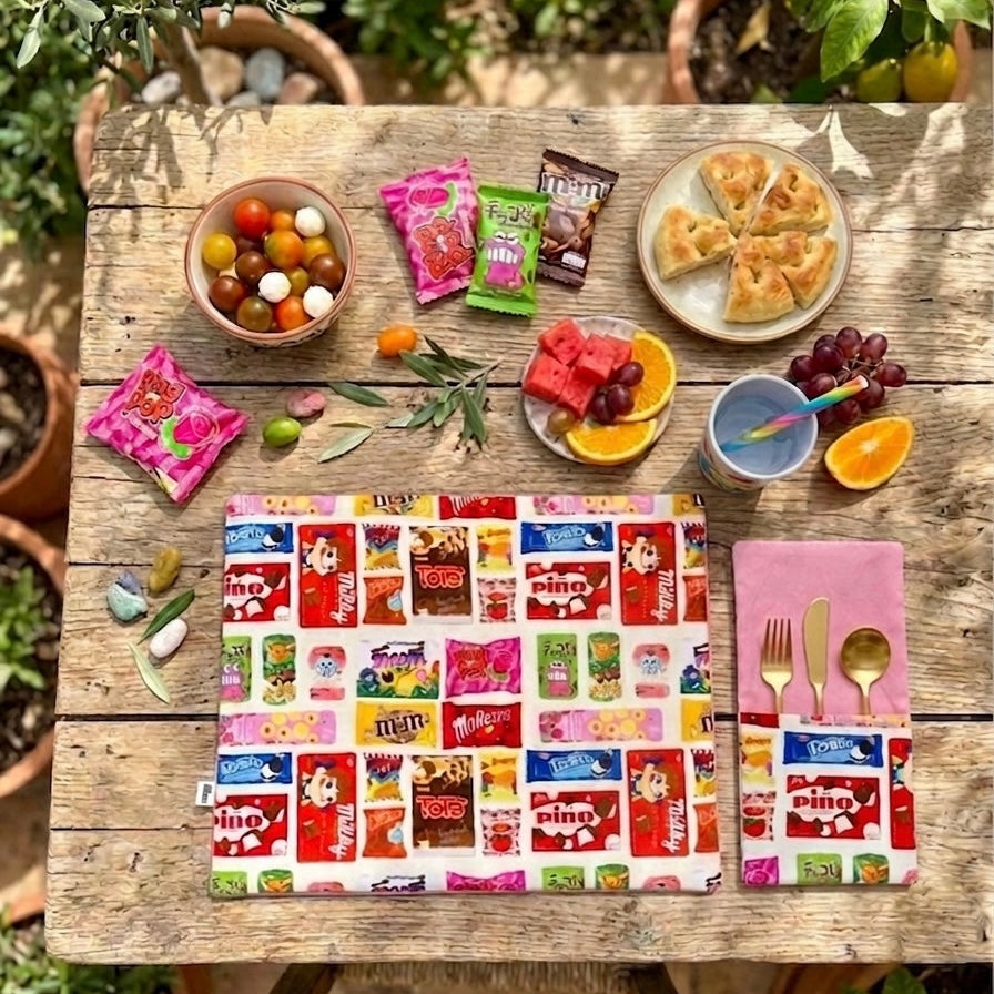 Pack de 2 servilletas con bolsillo para cubiertos en algodón 100%, con estampado inspirado en chocolatinas y diseño reversible. Un detalle divertido y funcional para mesas con personalidad, perfecto para sobremesas bonitas, regalos originales y mesas con mucho carácter.
