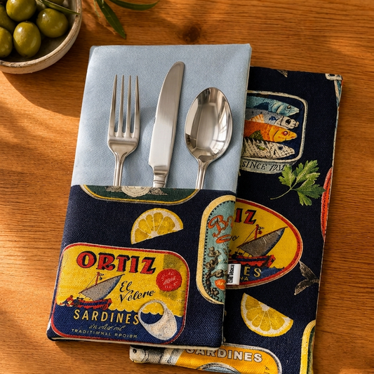 tres servilletas de algodon con bolsillo para cubiertos en algodón azul clarito y reves y cbolsillo en estampado de latas con fondo azul marino