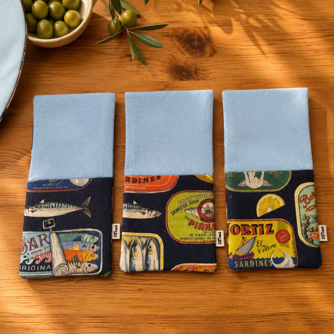 tres servilletas de algodon con bolsillo para cubiertos en algodón azul clarito y reves y cbolsillo en estampado de latas con fondo azul marino